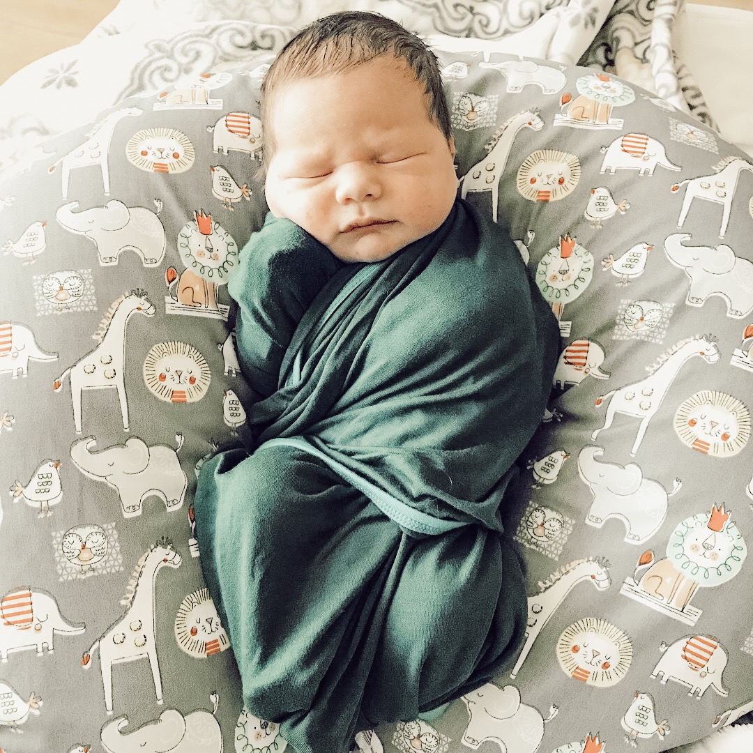 Newborn baby wrapped in kickee pants blanket