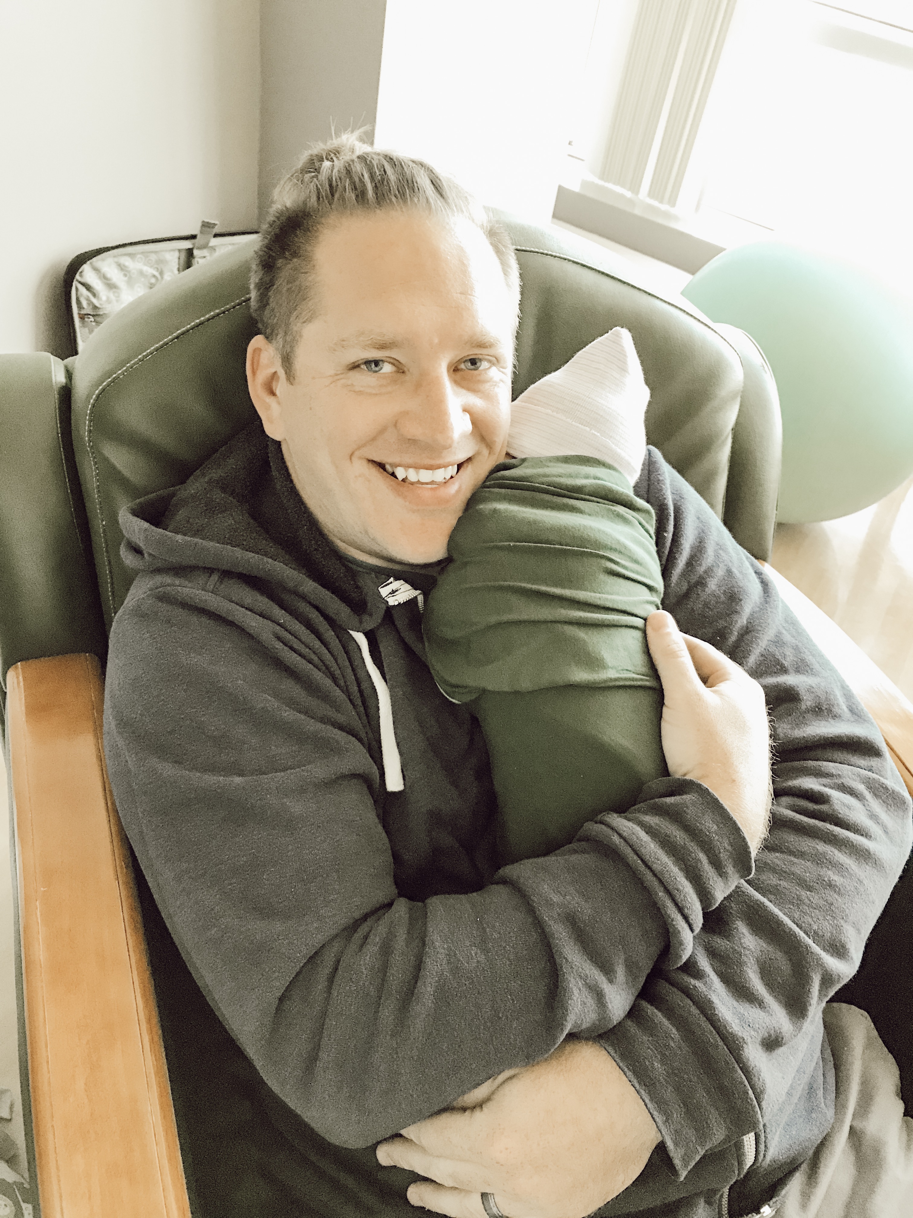 New dad with newborn baby wrapped in kickee pants blanket