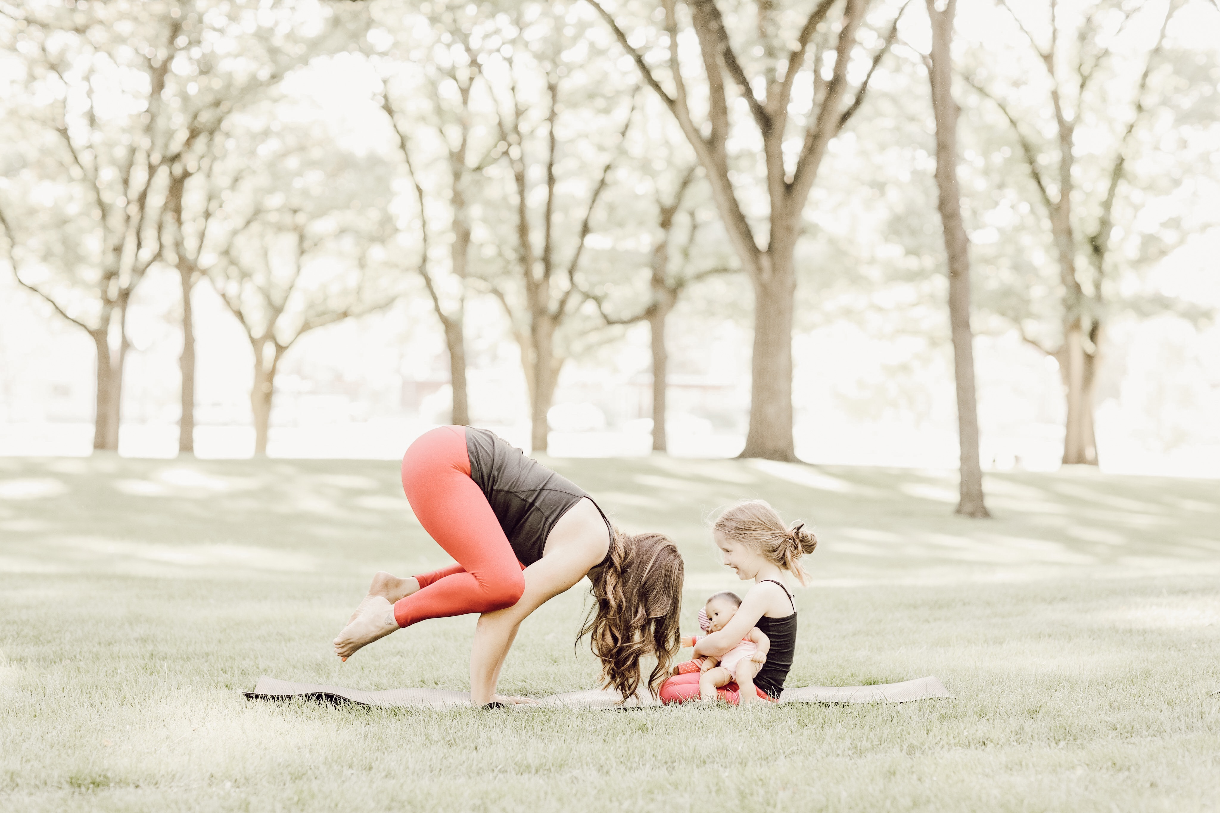 Mother and daughter doing crow pose in yoga